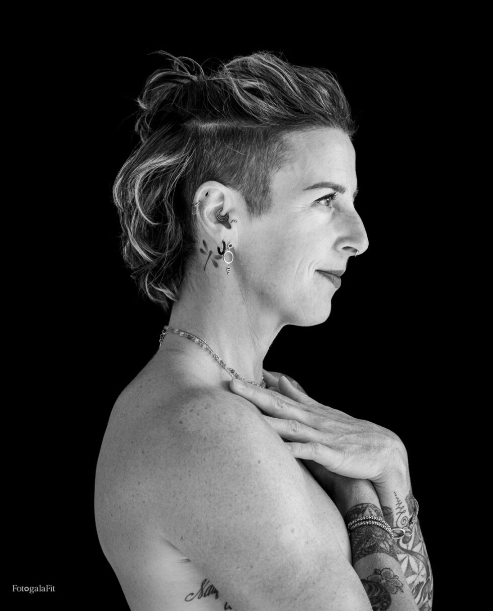 Retrato artístico en blanco y negro de Mathilde, de perfil, con las manos sobre el pecho y fondo negro. Fotografía de Fotogalafit.